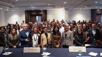 Crowd of attendees posing for a large group photo in a conference room.