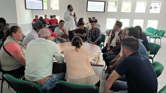 Group of people seated in a bright room, gathered for a workshop discussion.