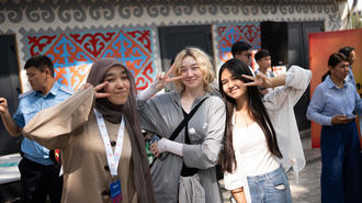 Group of friends posing for a photograph outdoors in front of a blue patterned wall.