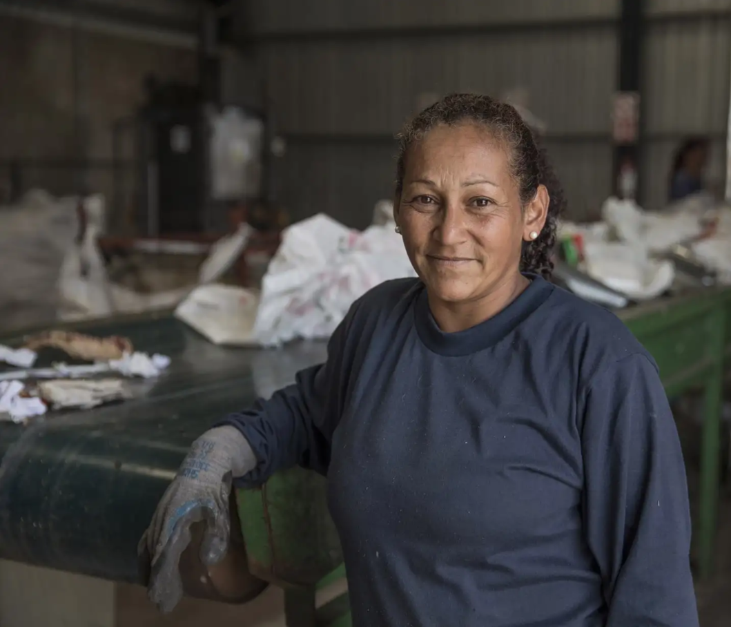 Mujer clasificadora de residuos en planta de clasificación