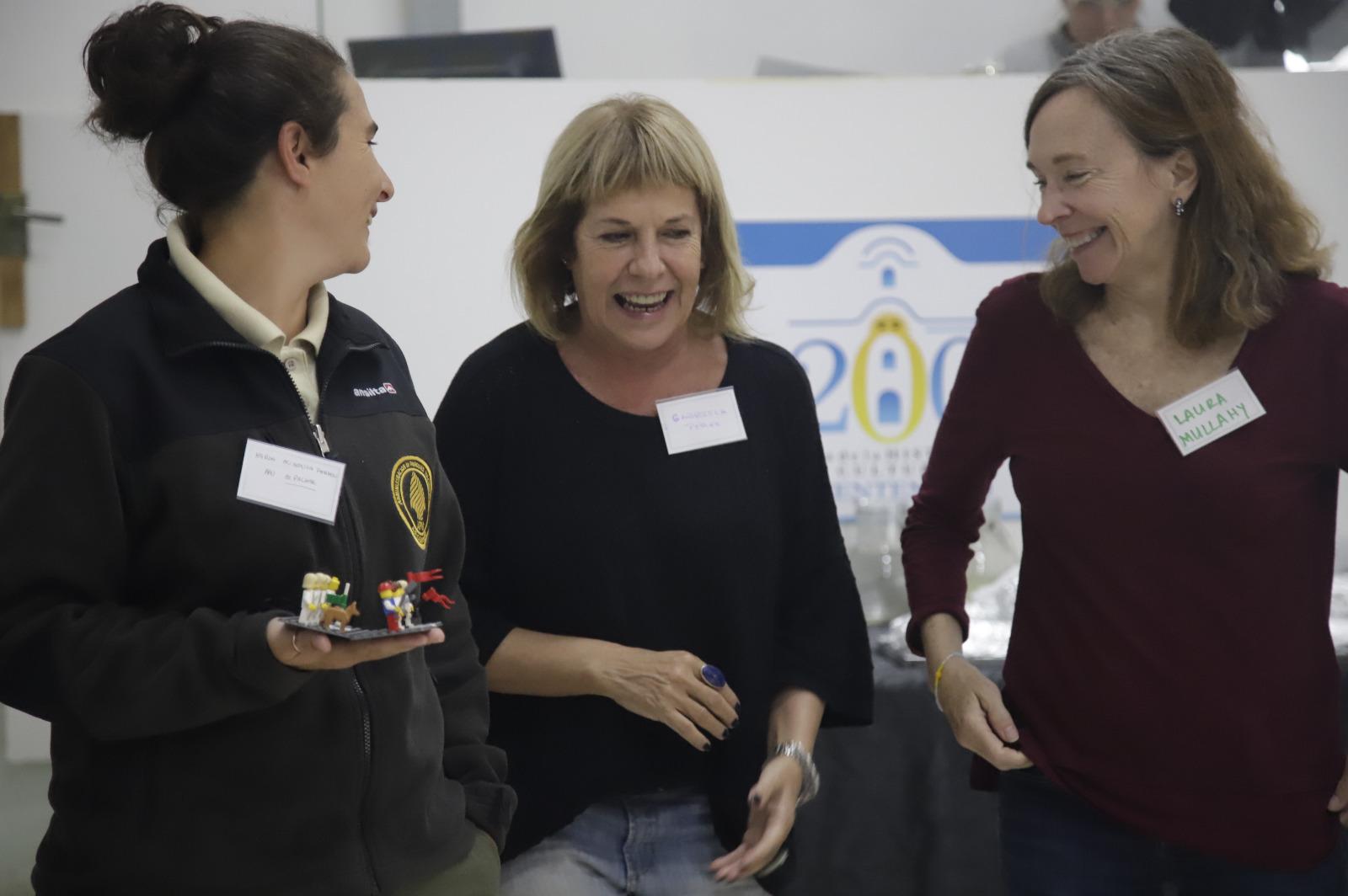 Tres mujeres sonríen durante presentación en curso sobre cambio climático 
