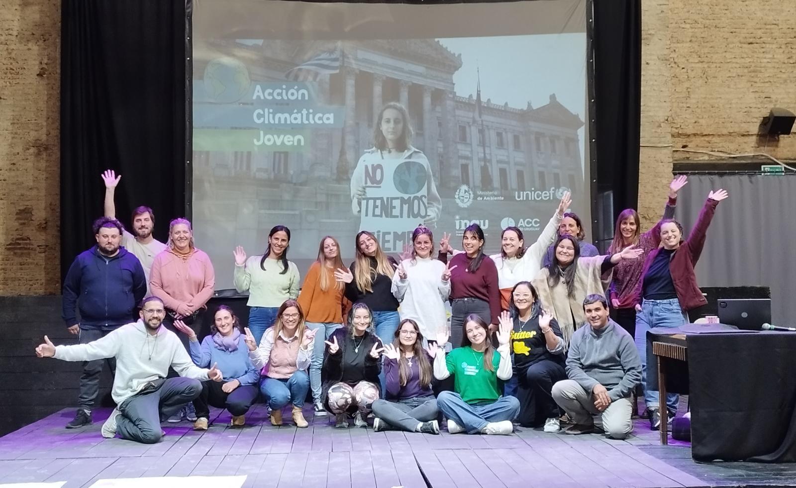 Foto grupal de educadoras y educadores saludan a la camara