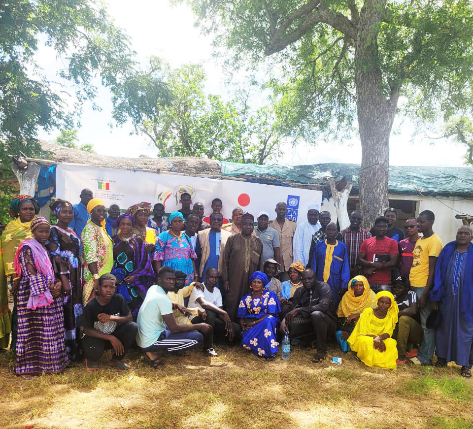 Groupe d'hommes et de femmes sous un arbre