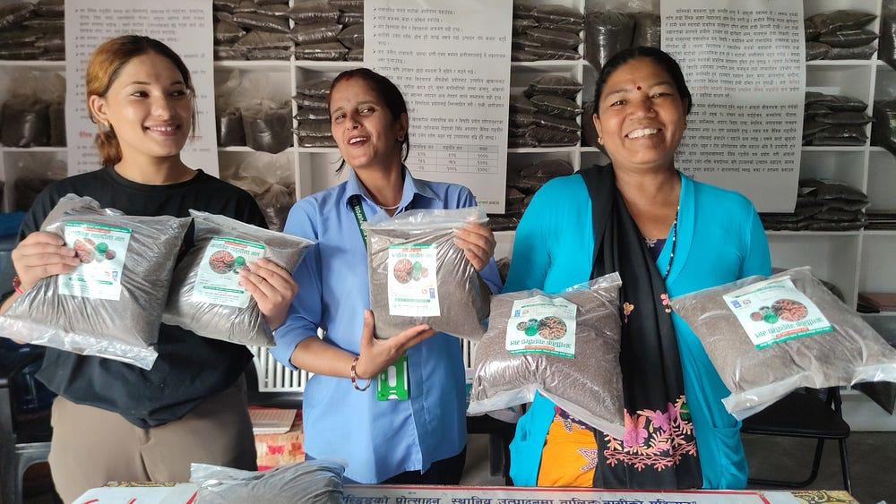 three women showing compost