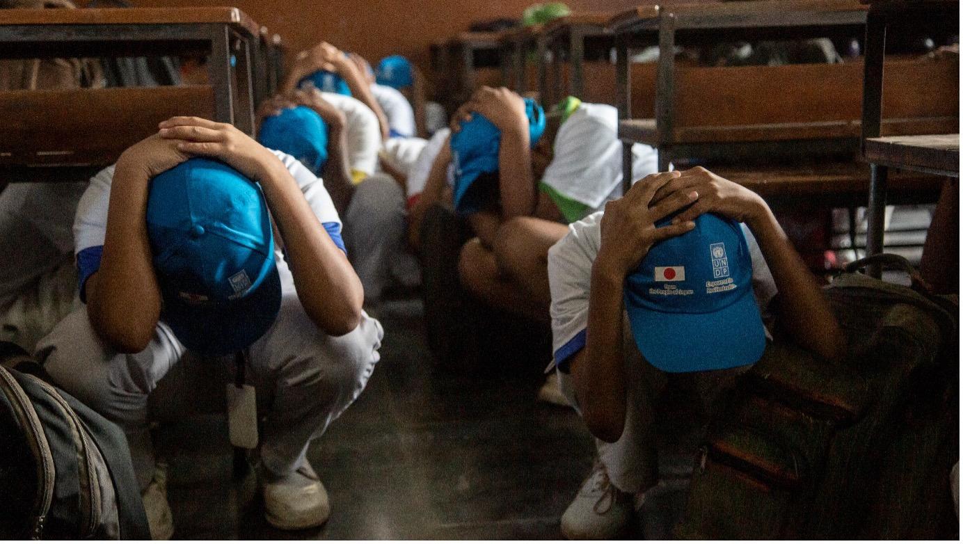 Sudents duck, cover and hold during a tsunami drill in India. 