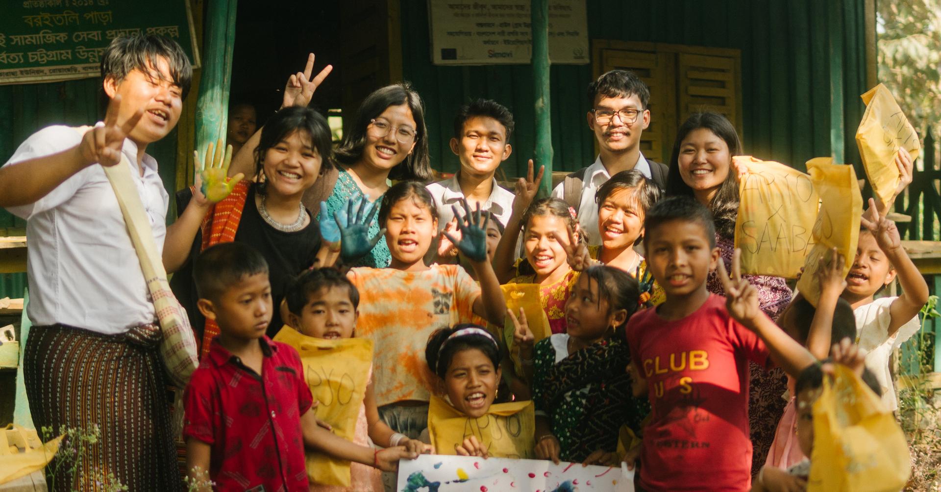 Young people posing for a photo, holding up peace signs