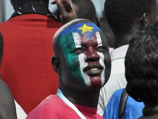 Man with South Sudan flag painted on face