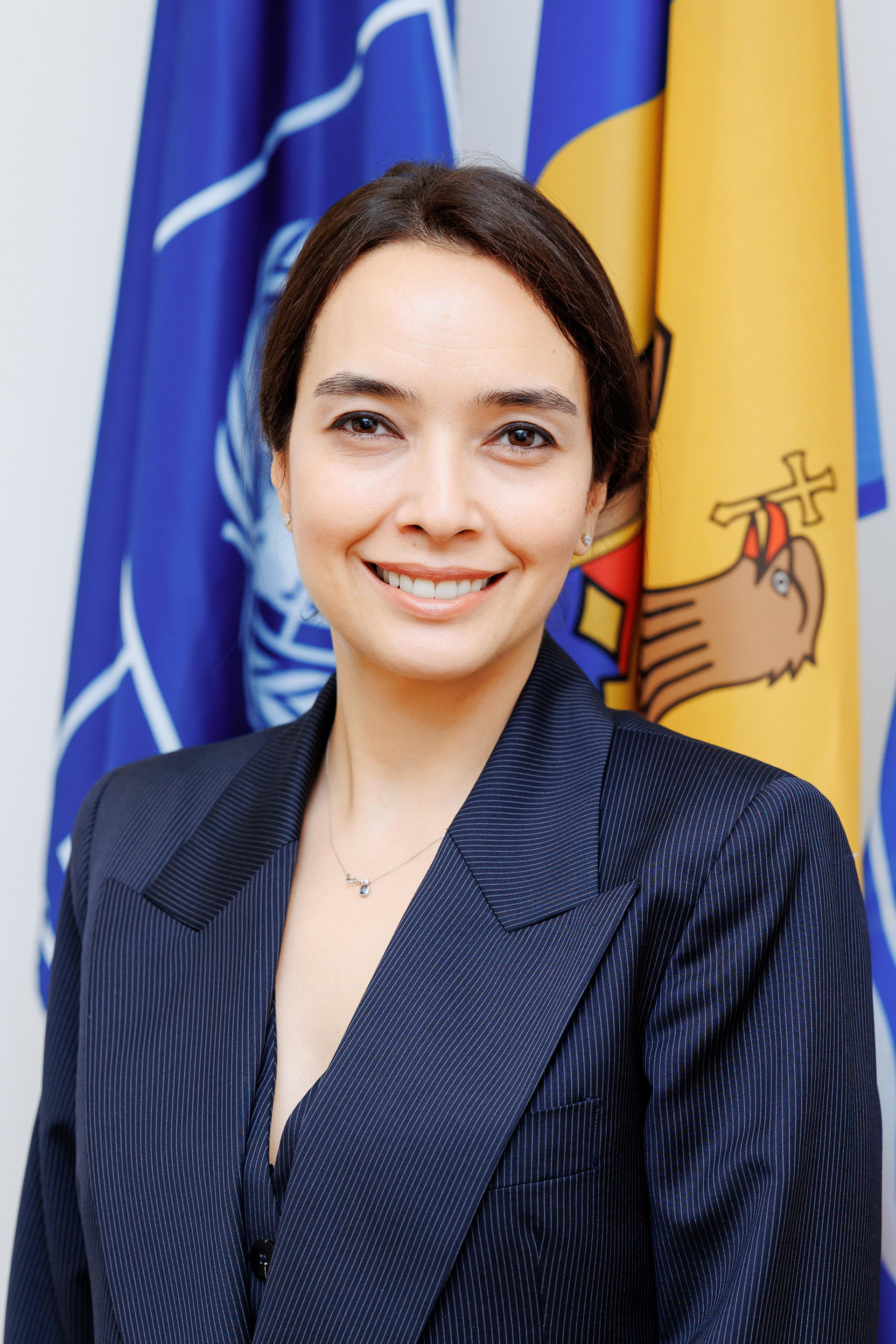 a person wearing a suit and tie smiling at the camera