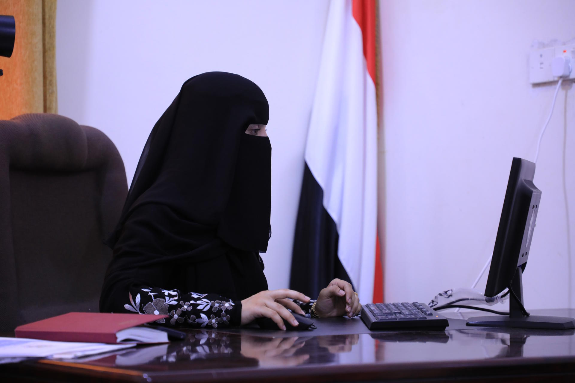 a person using a laptop computer sitting on top of a desk