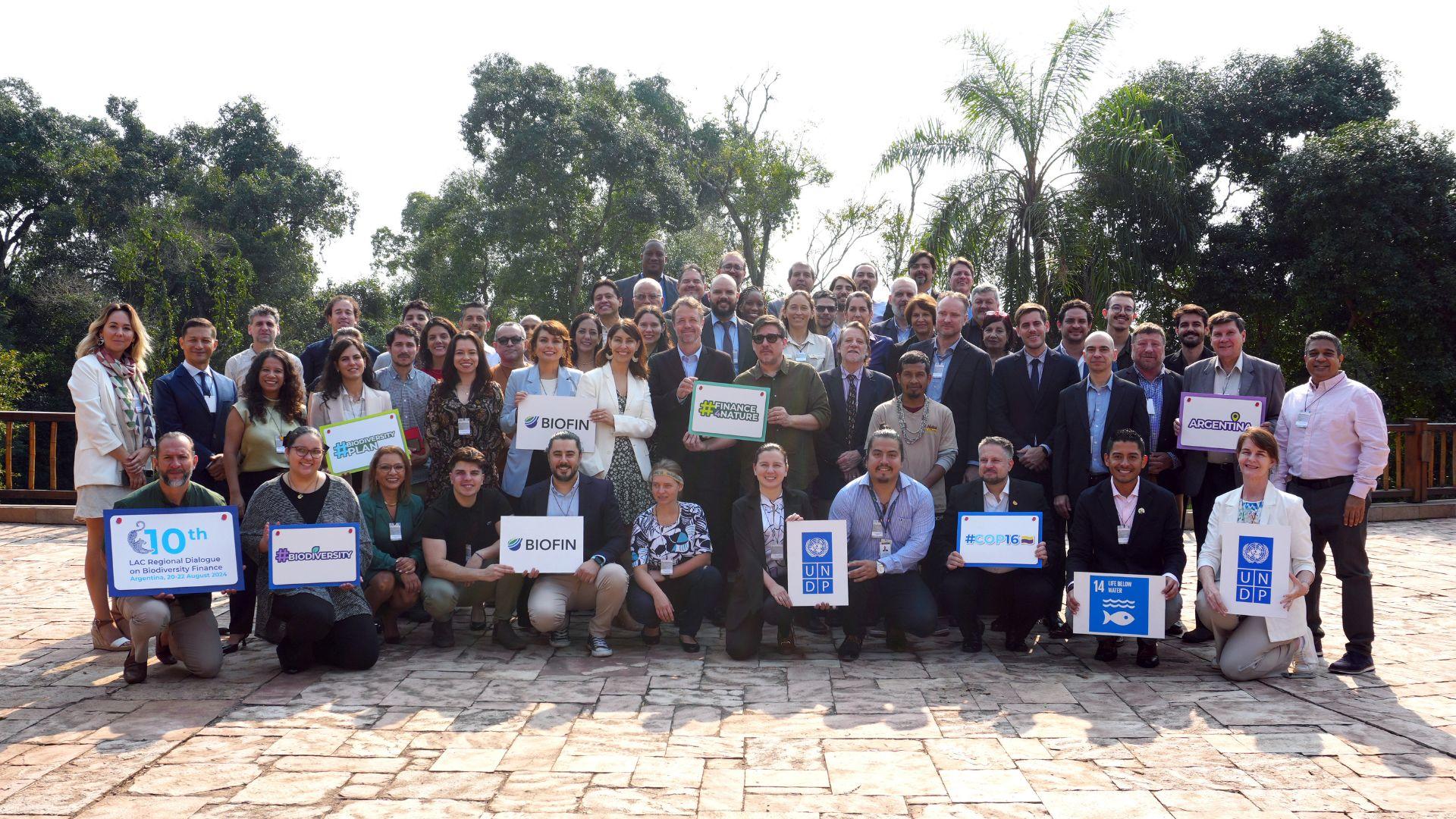 Un grupo de personas de pie frente a una multitud posando para la cámara