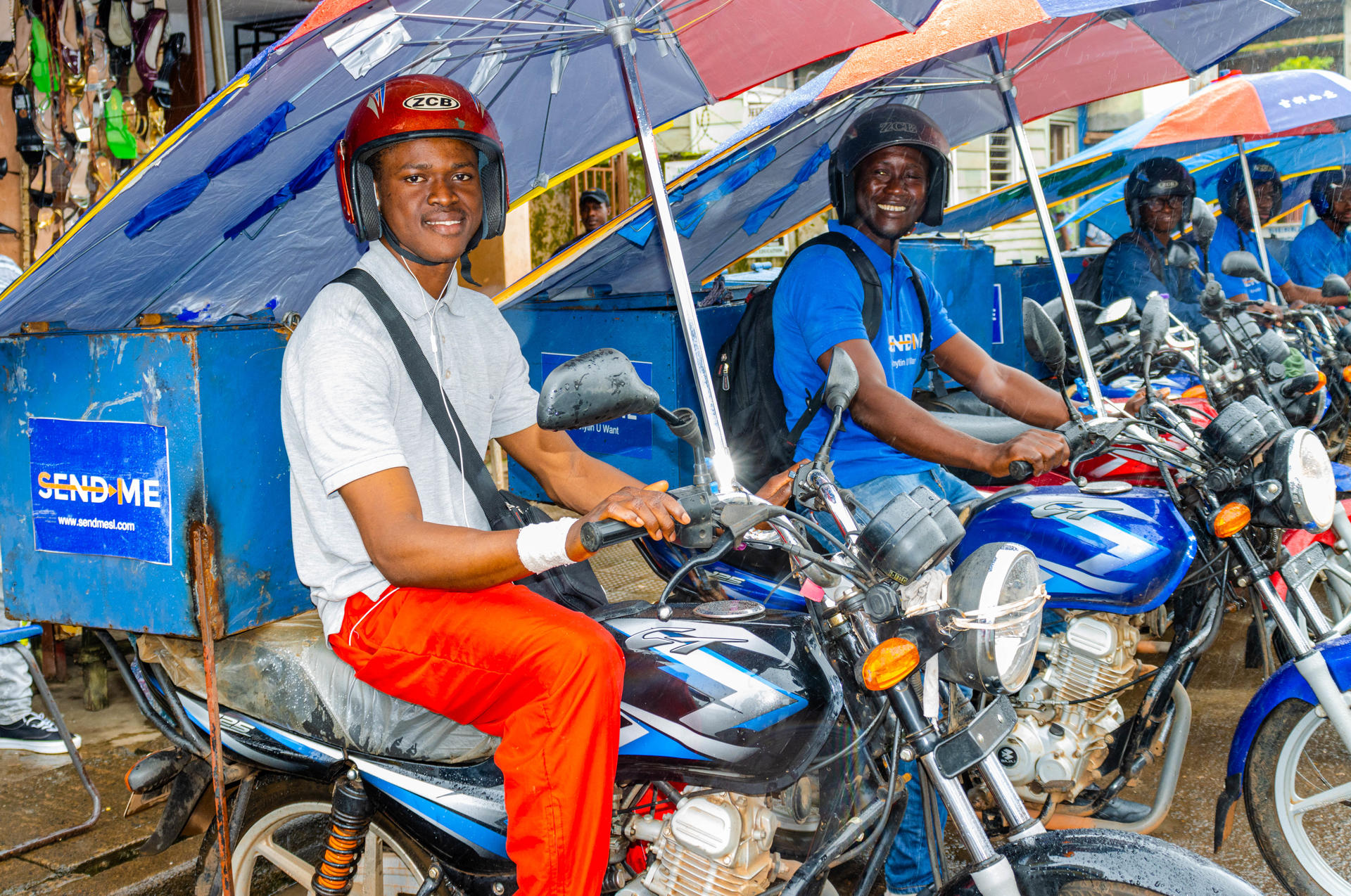 a person riding a motorcycle with a blue umbrella