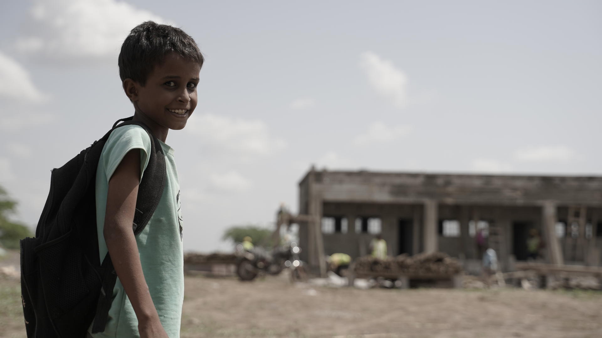 a young boy standing on a dirt road