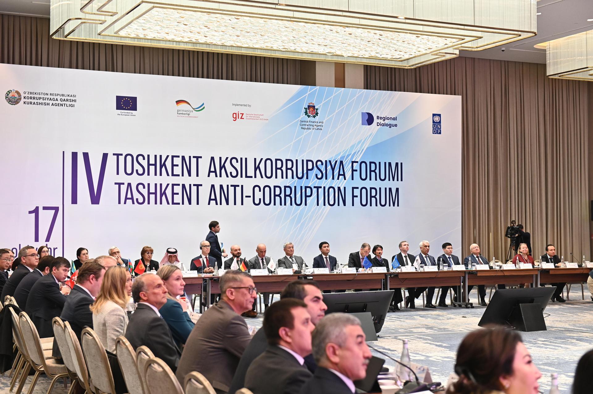 A large banner of the Forum and a group of people sitting next to it