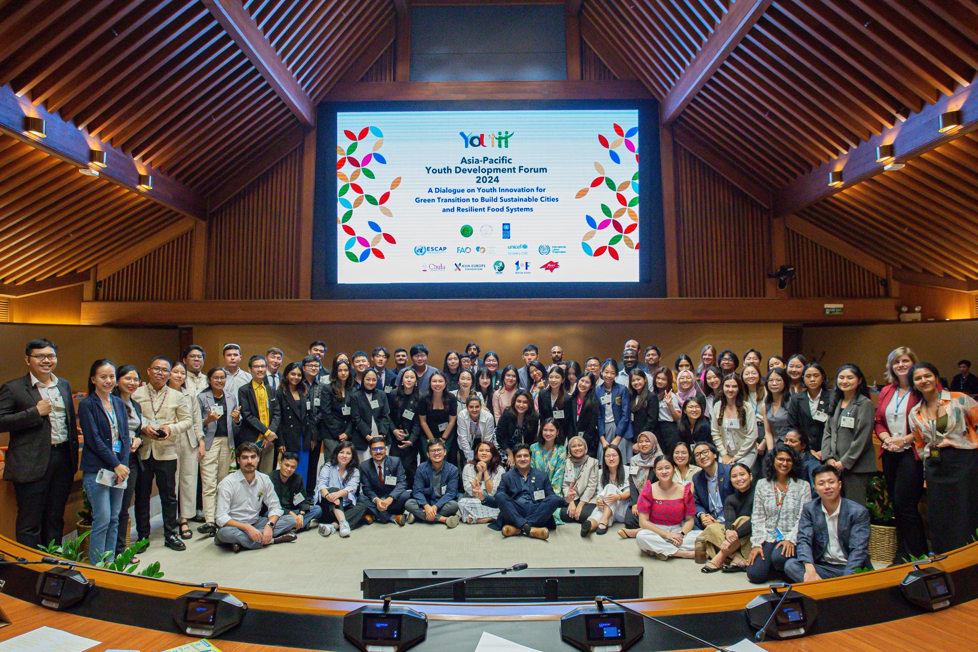 a group of delegates smiling in front of a conference room