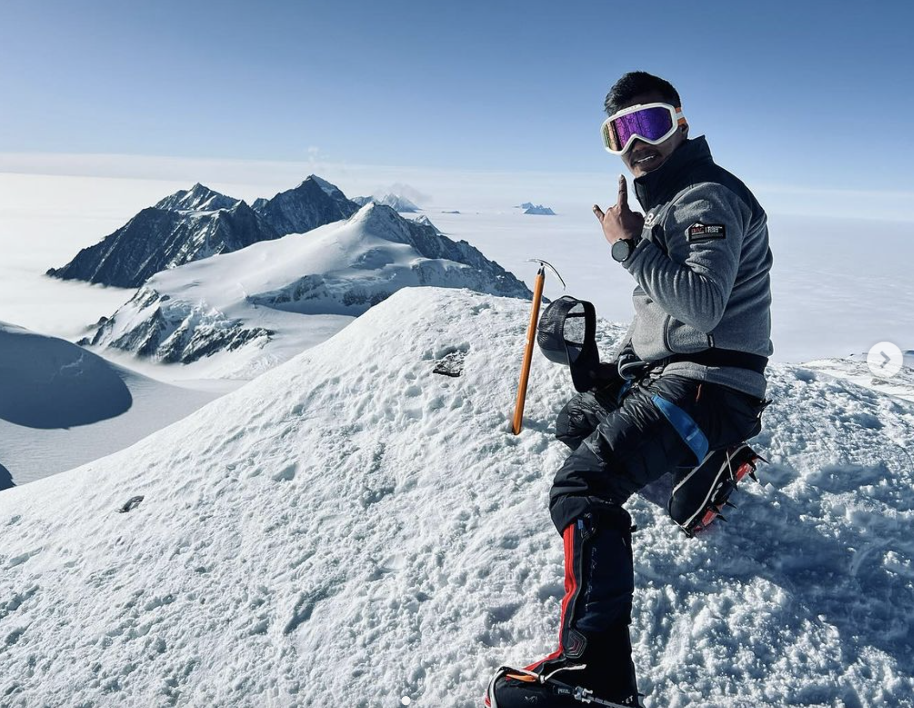 a man standing on top of a snow covered slope