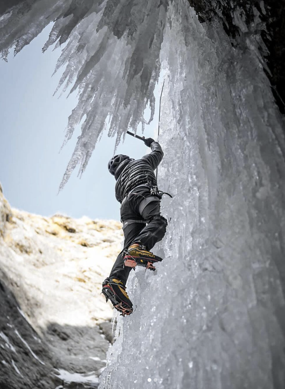 a man climbing a snow covered slope