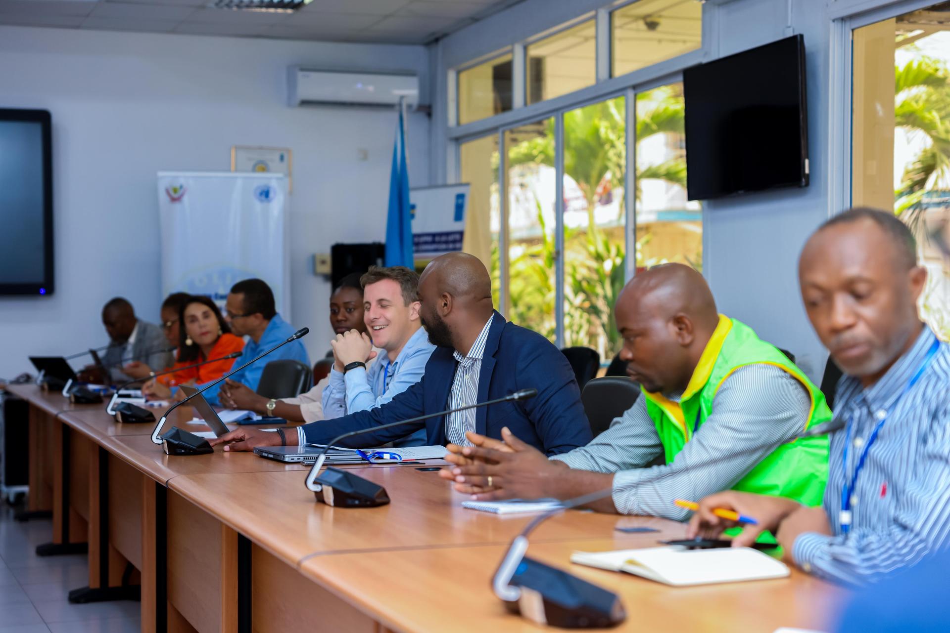 un groupe de personnes assises à une table avec un ordinateur portable