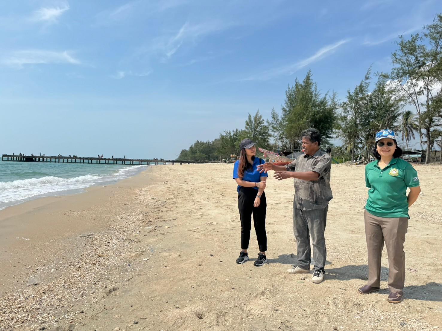 a group of people standing on top of a sandy beach