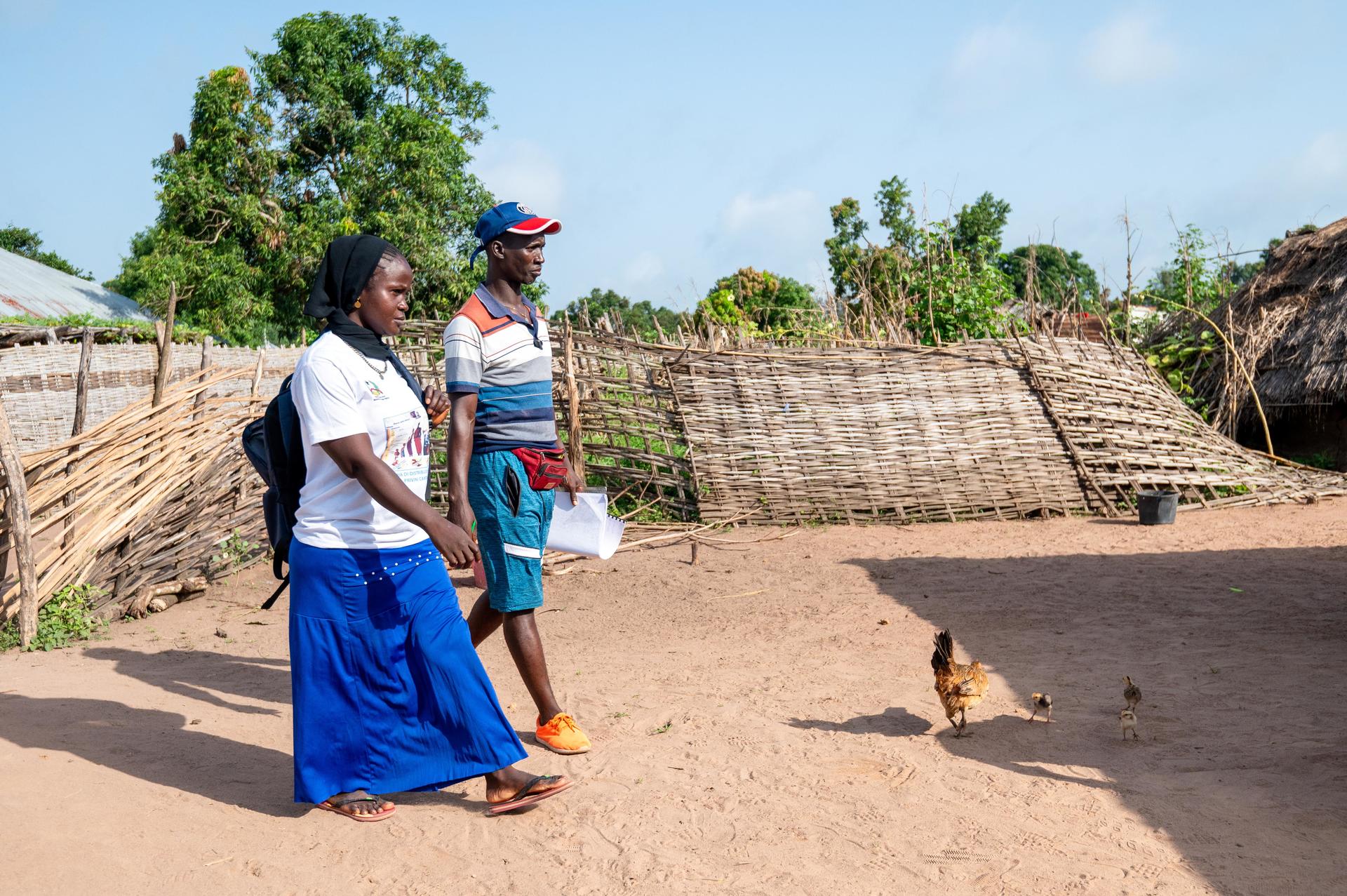 a man and a woman walking down a dirt road