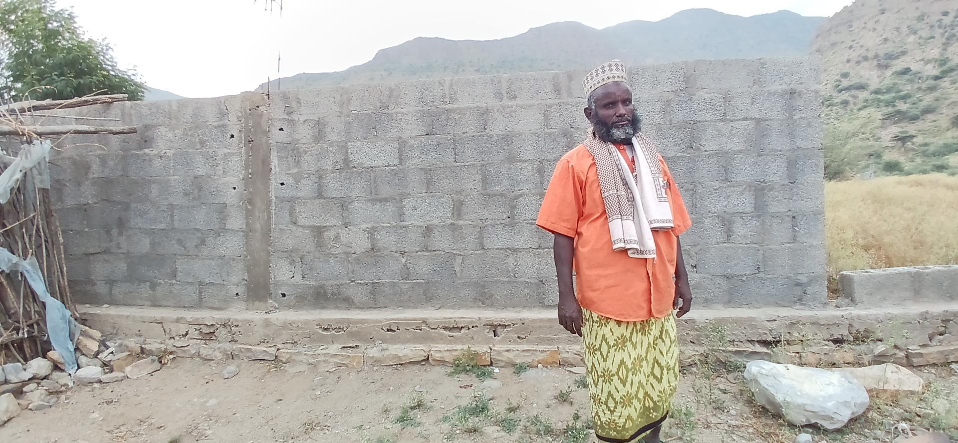 a man standing in front of a stone building