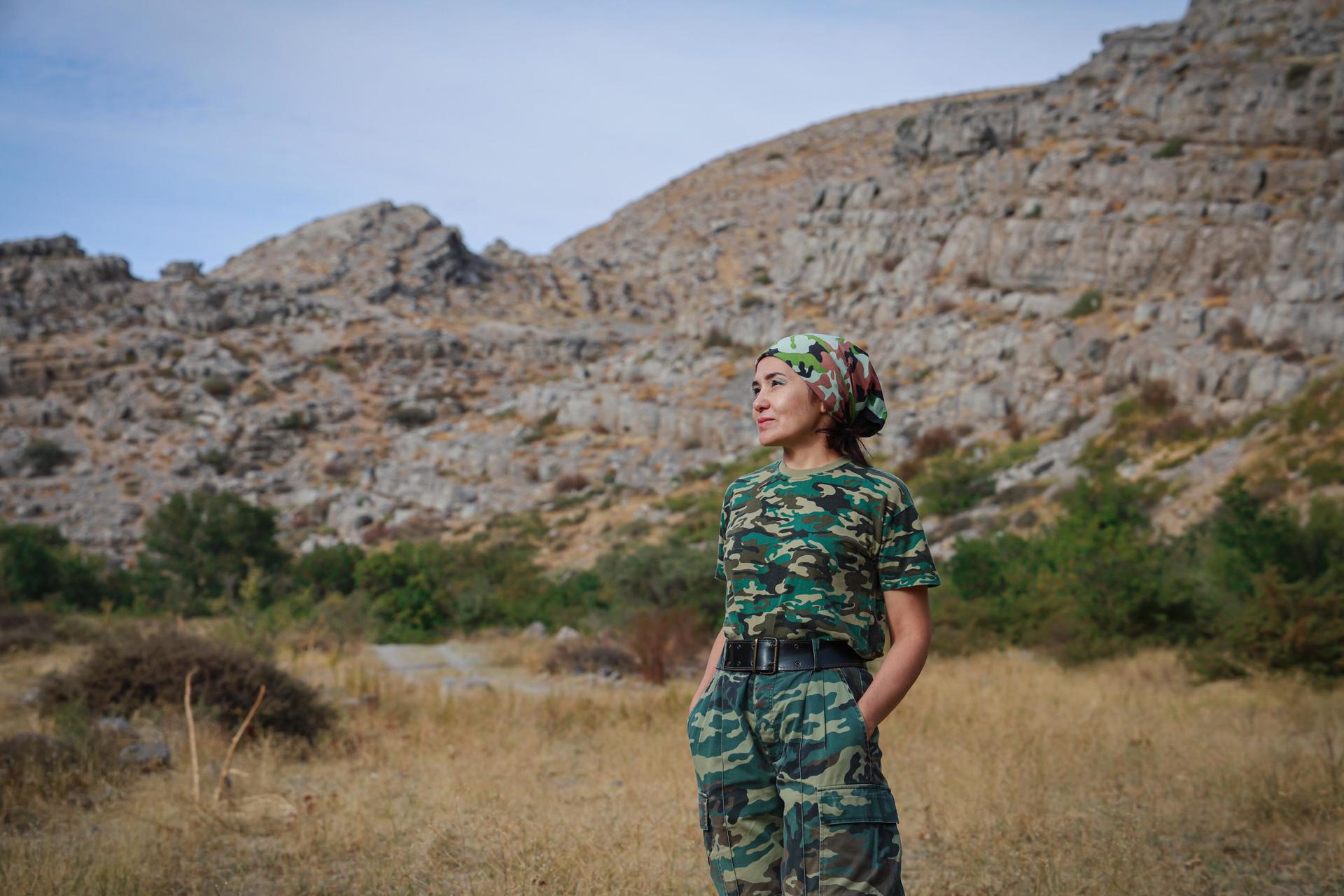 a woman standing in front of a mountain