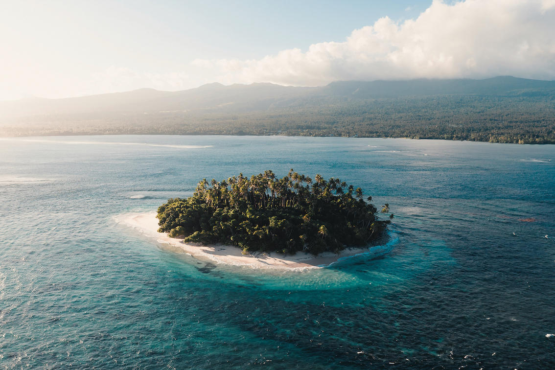 a body of water with a mountain in the ocean