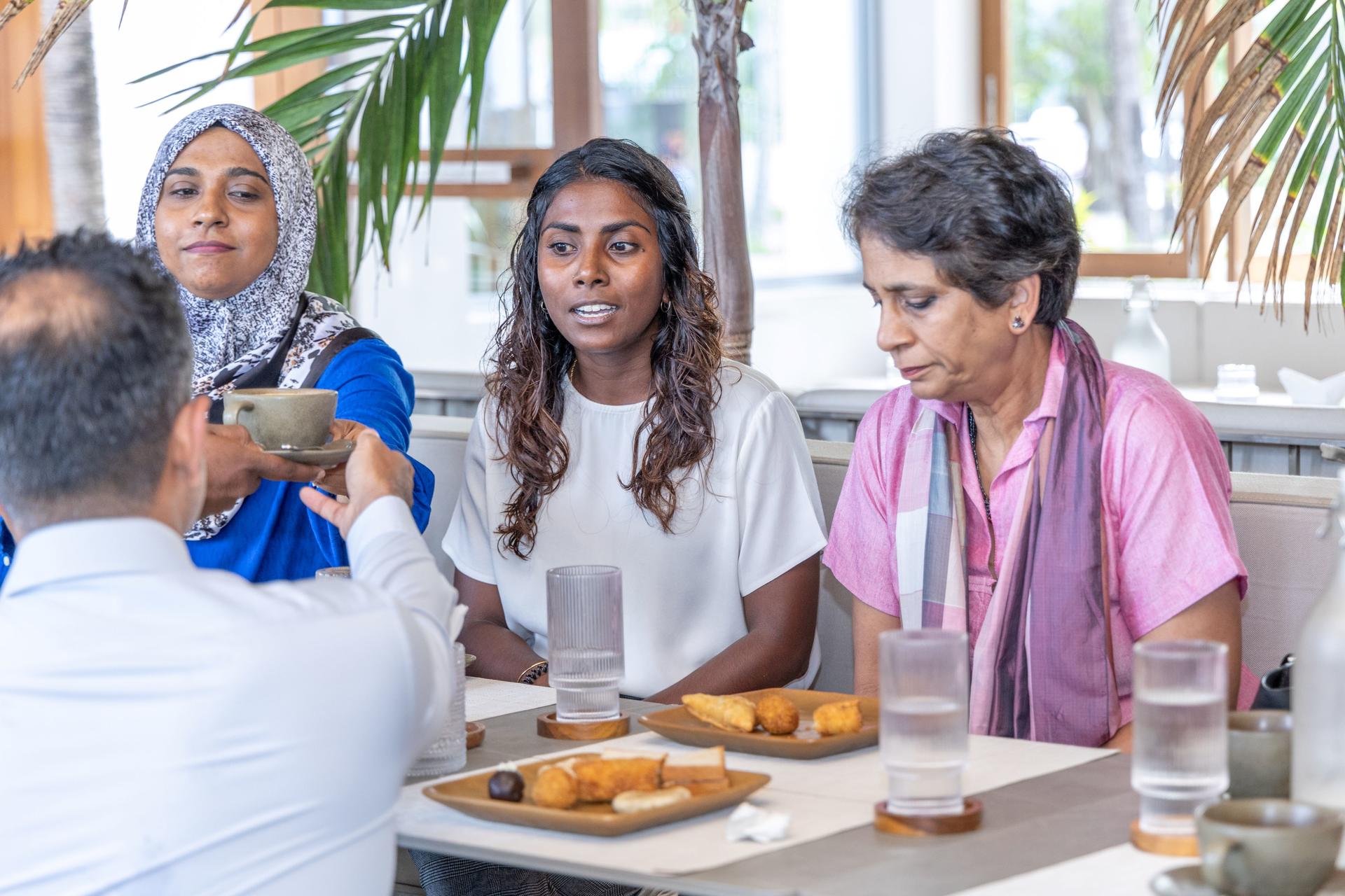 a group of people sitting at a table with food