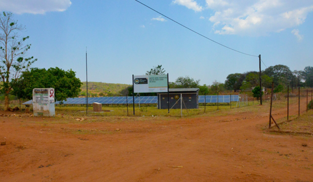 a sign on the side of a dirt field
