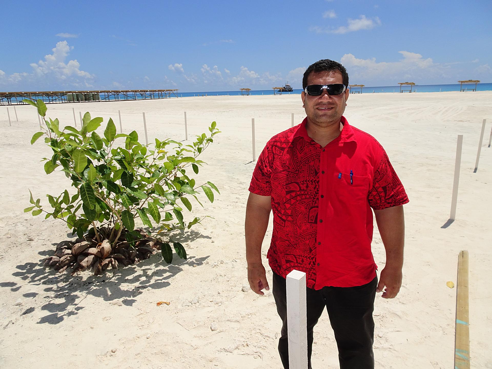 a man standing on a beach posing for the camera