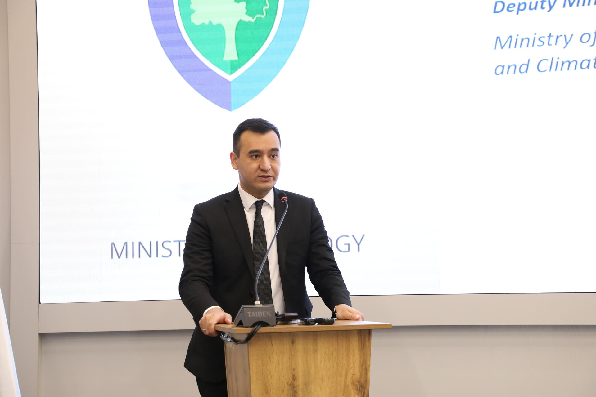 a man in a suit standing in front of a sign