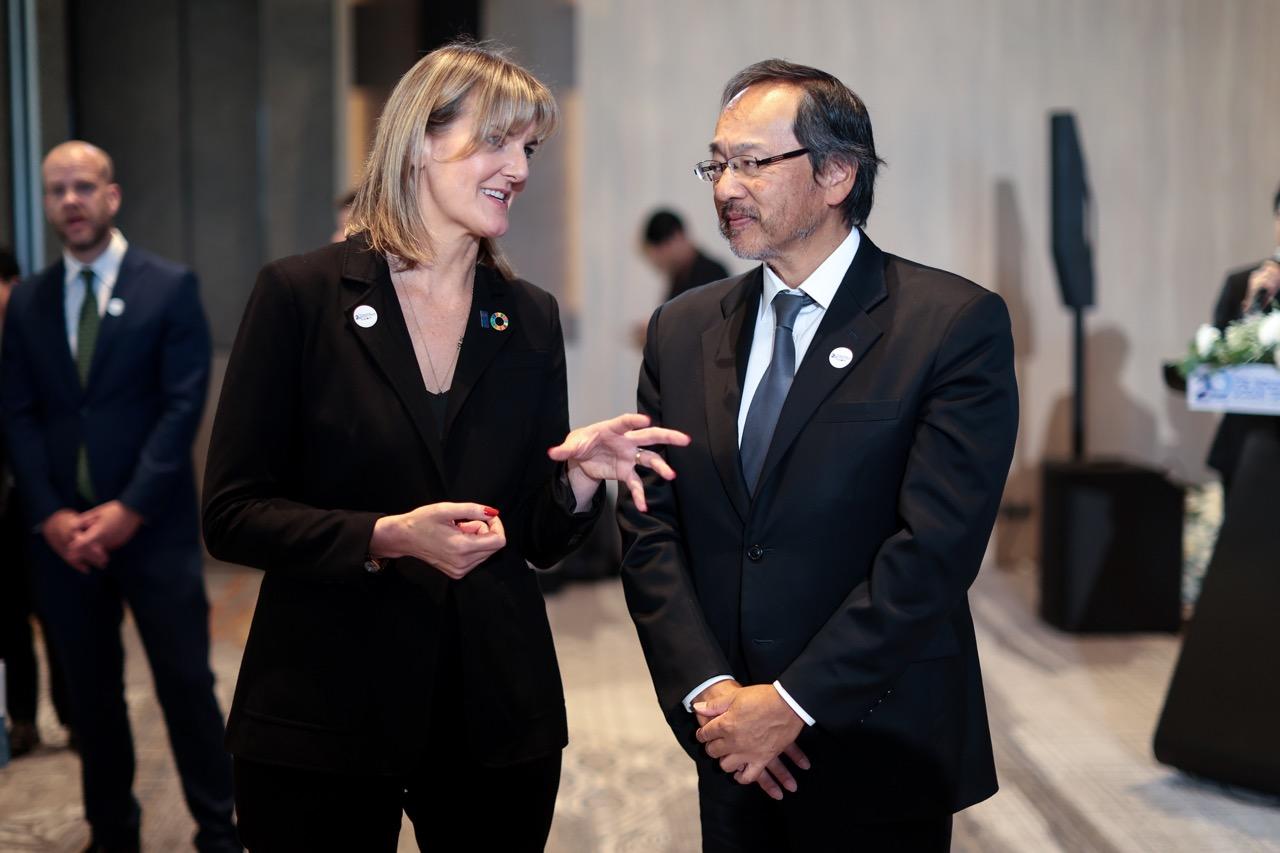 a woman standing next to a man in a suit and tie