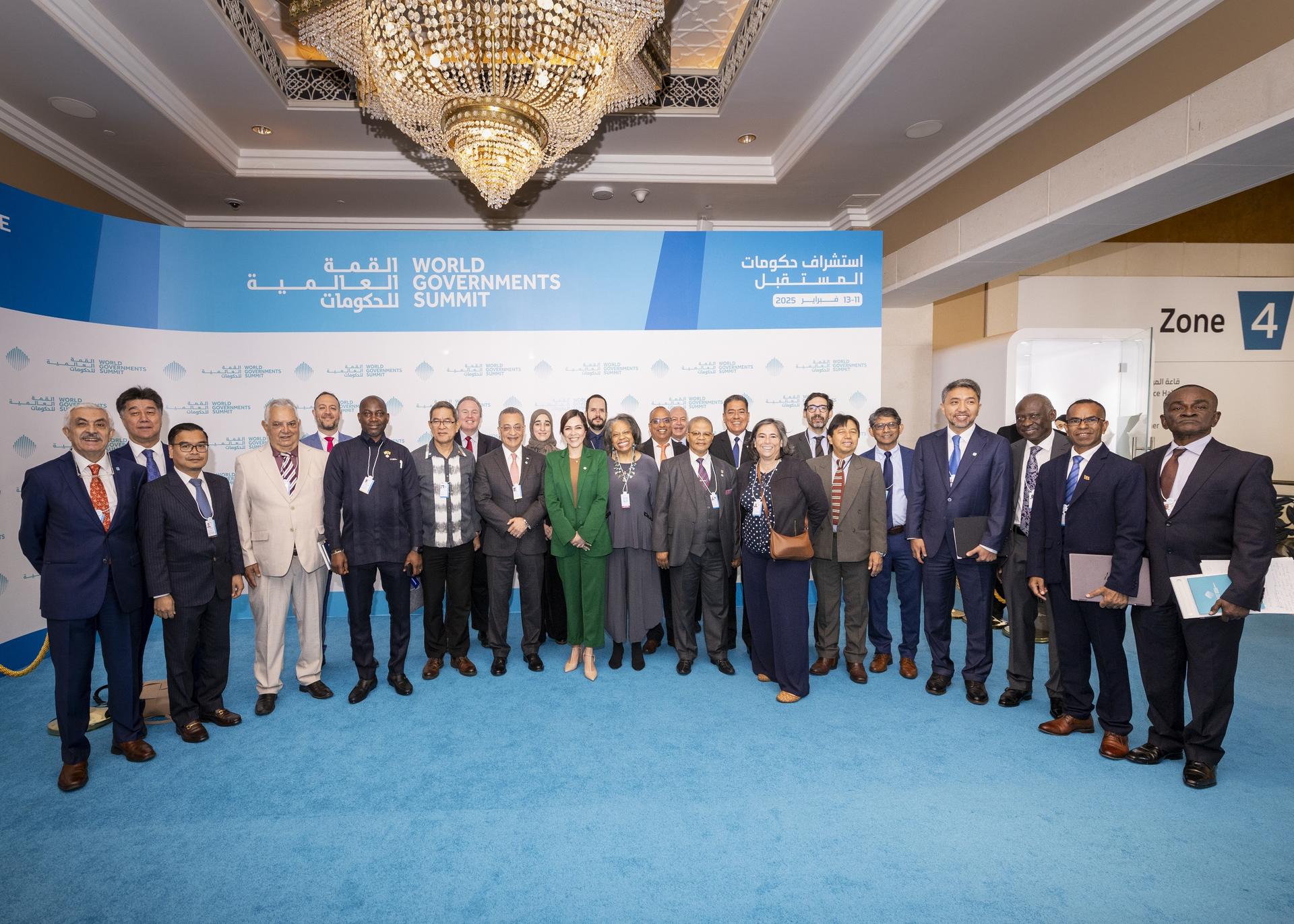 Group of diverse professionals posing together at a conference, smiling in a formal setting.