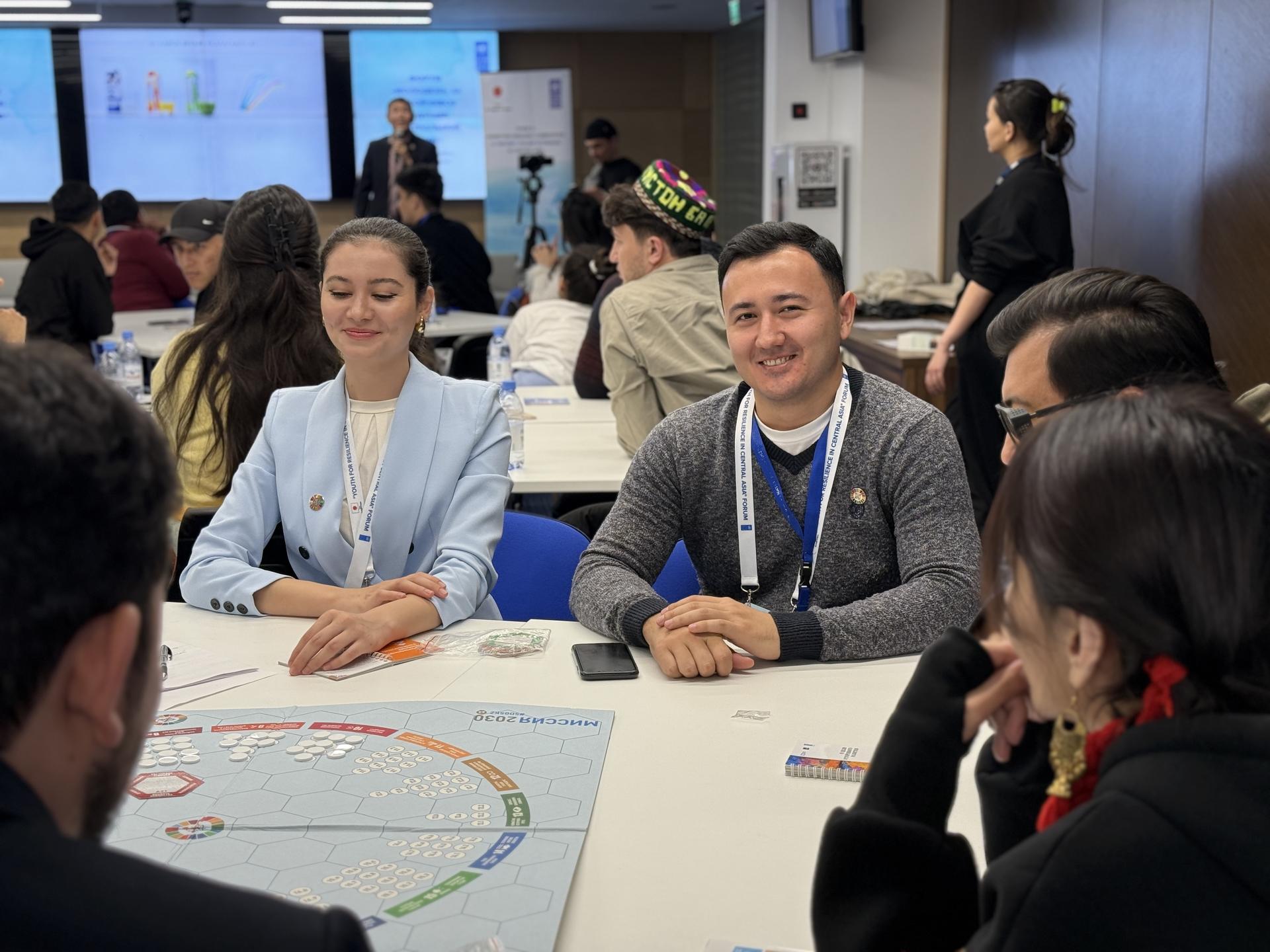 Group of people at a table engaging in discussion, smiling and sharing ideas.