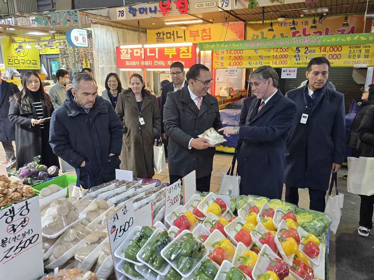 Market scene with people engaging near colorful produce displays.