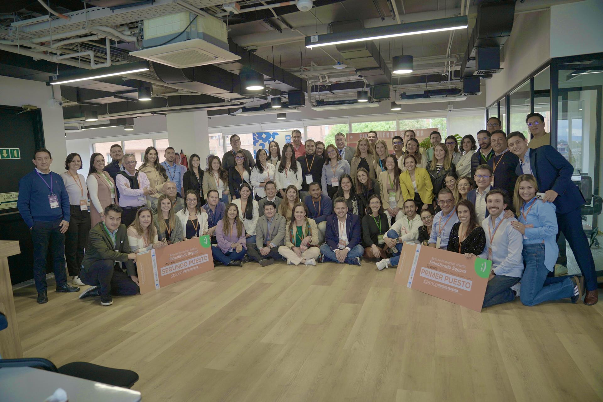 A large group of diverse people gathered together in a modern office space.