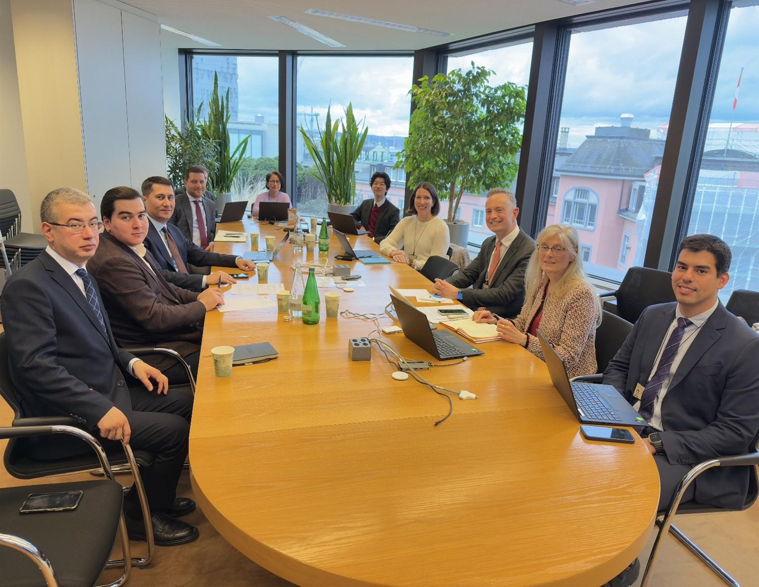 Group of professionals seated around a large conference table in an office setting.