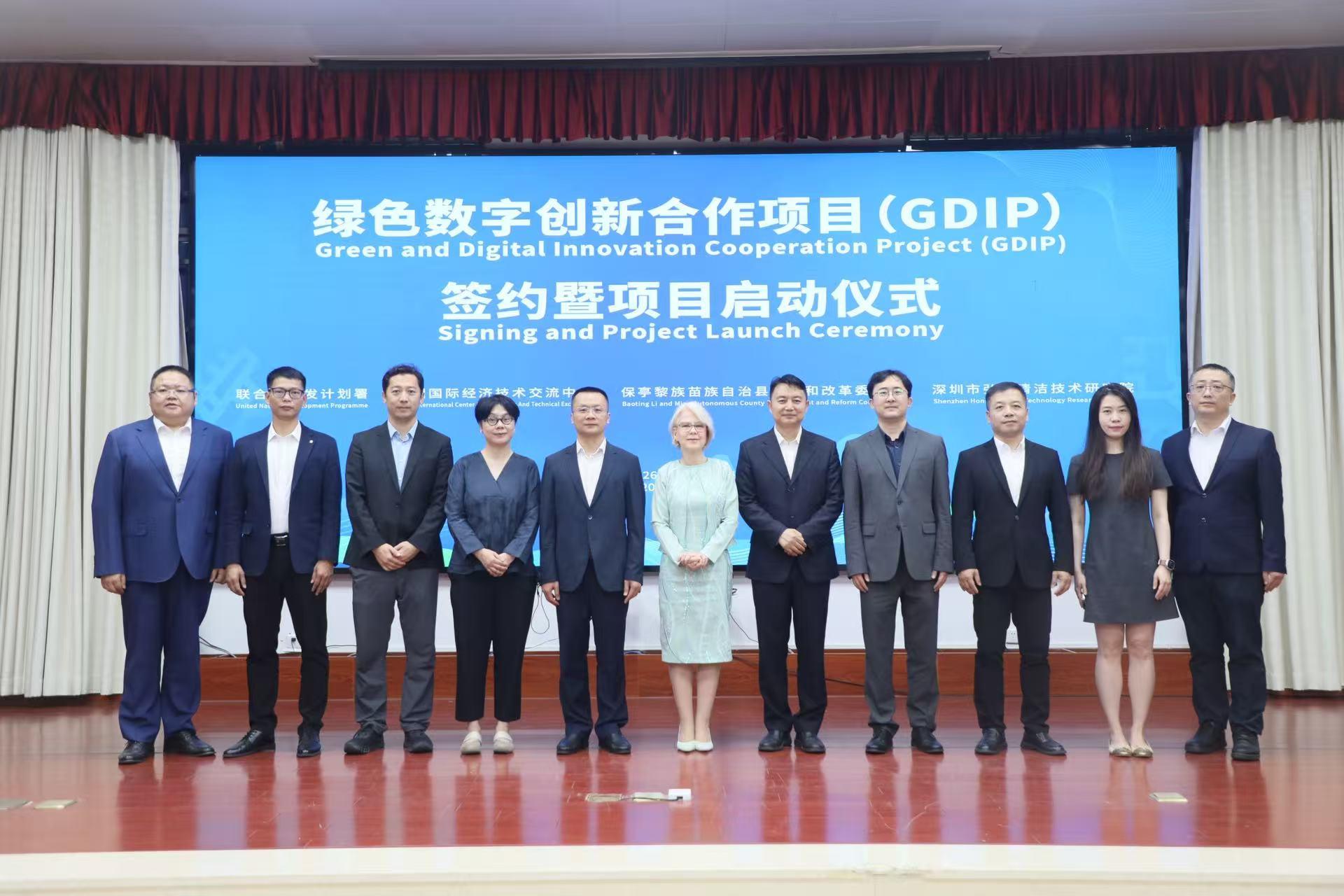 A group of professionals standing together on a stage, smiling, with a banner in the background.