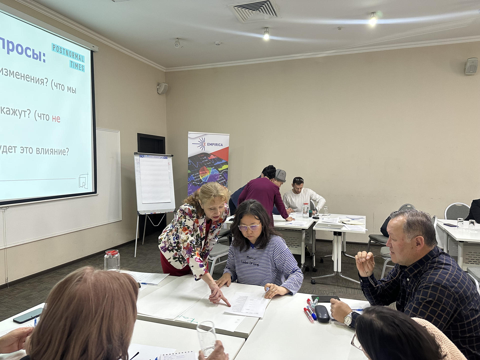 A group of people collaborating in a meeting room, reviewing documents and discussing.