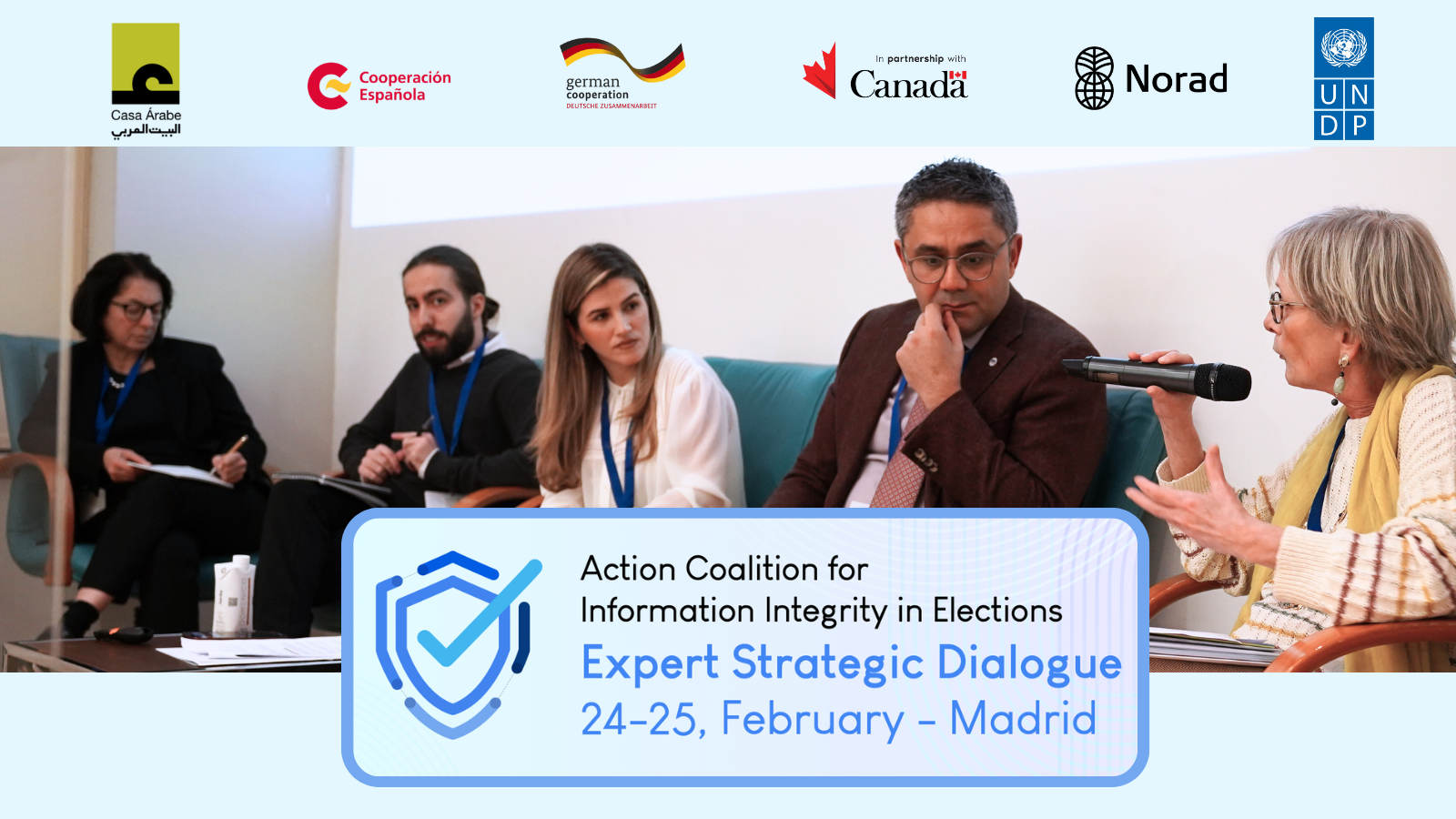 Panel discussion featuring four speakers with a banner for an expert strategic dialogue in Madrid.