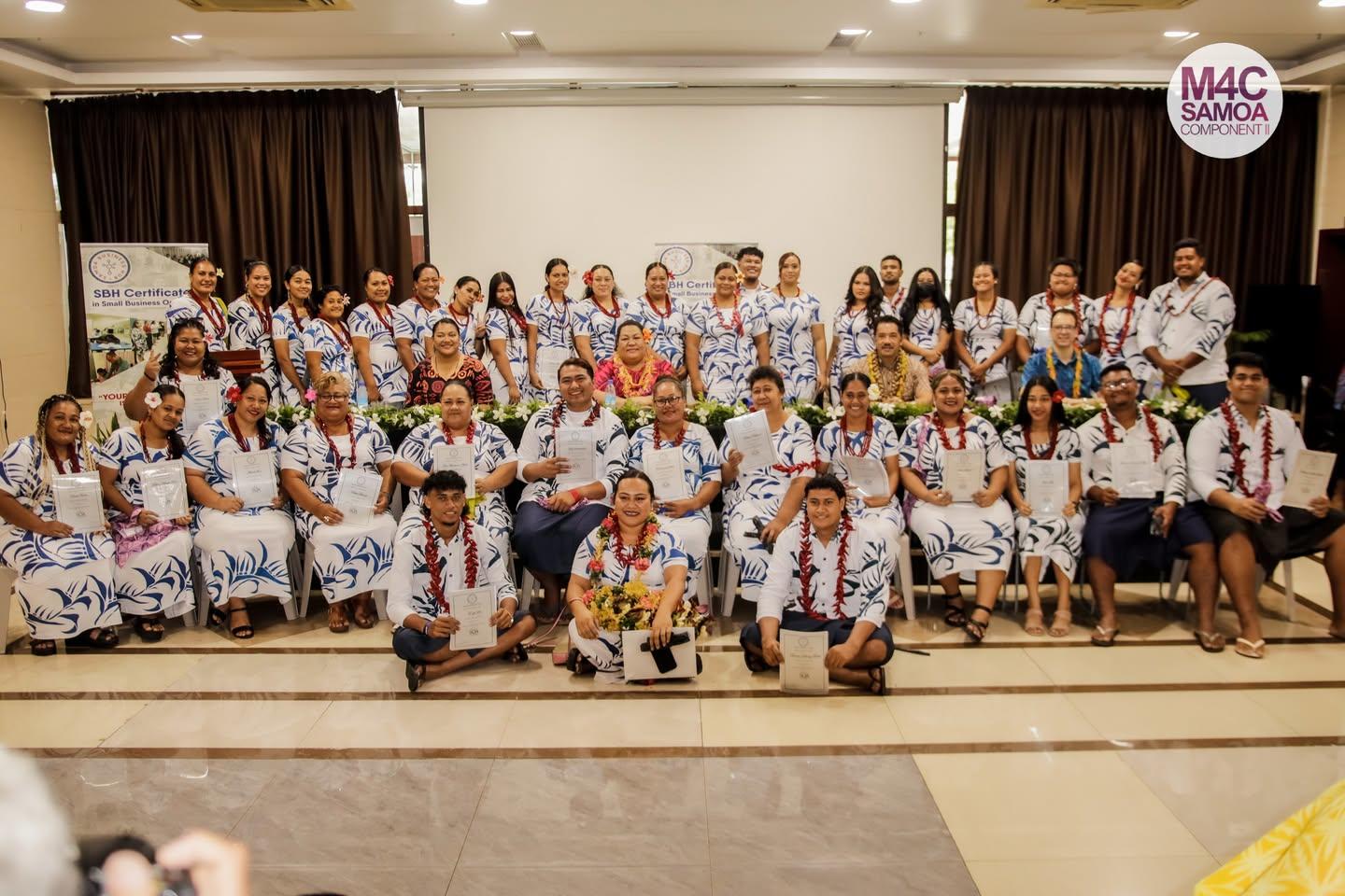 Group photo of a diverse crowd in matching shirts, posing together in a well-lit indoor setting.