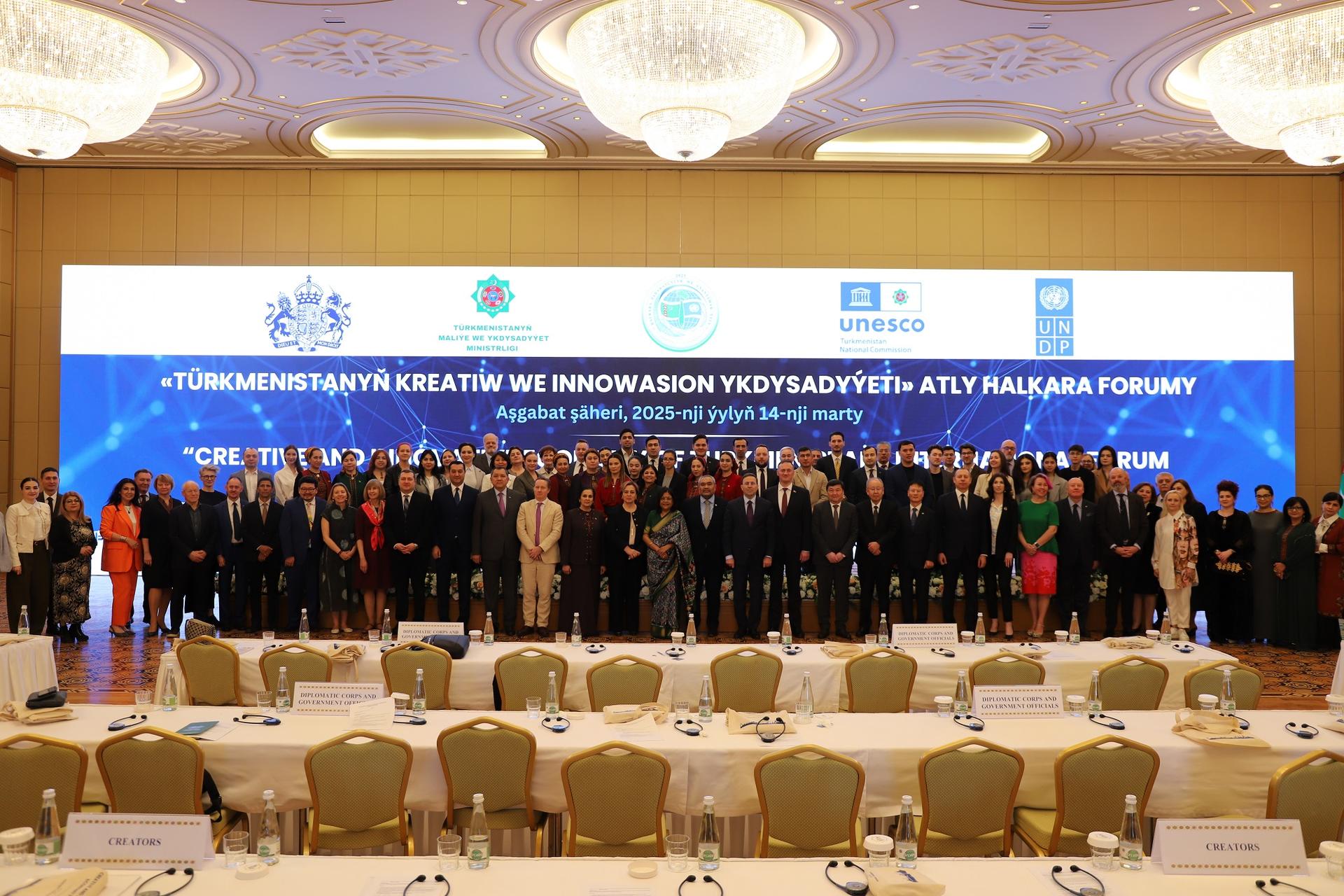 Group photo of diverse individuals standing together at a formal event in a banquet hall.