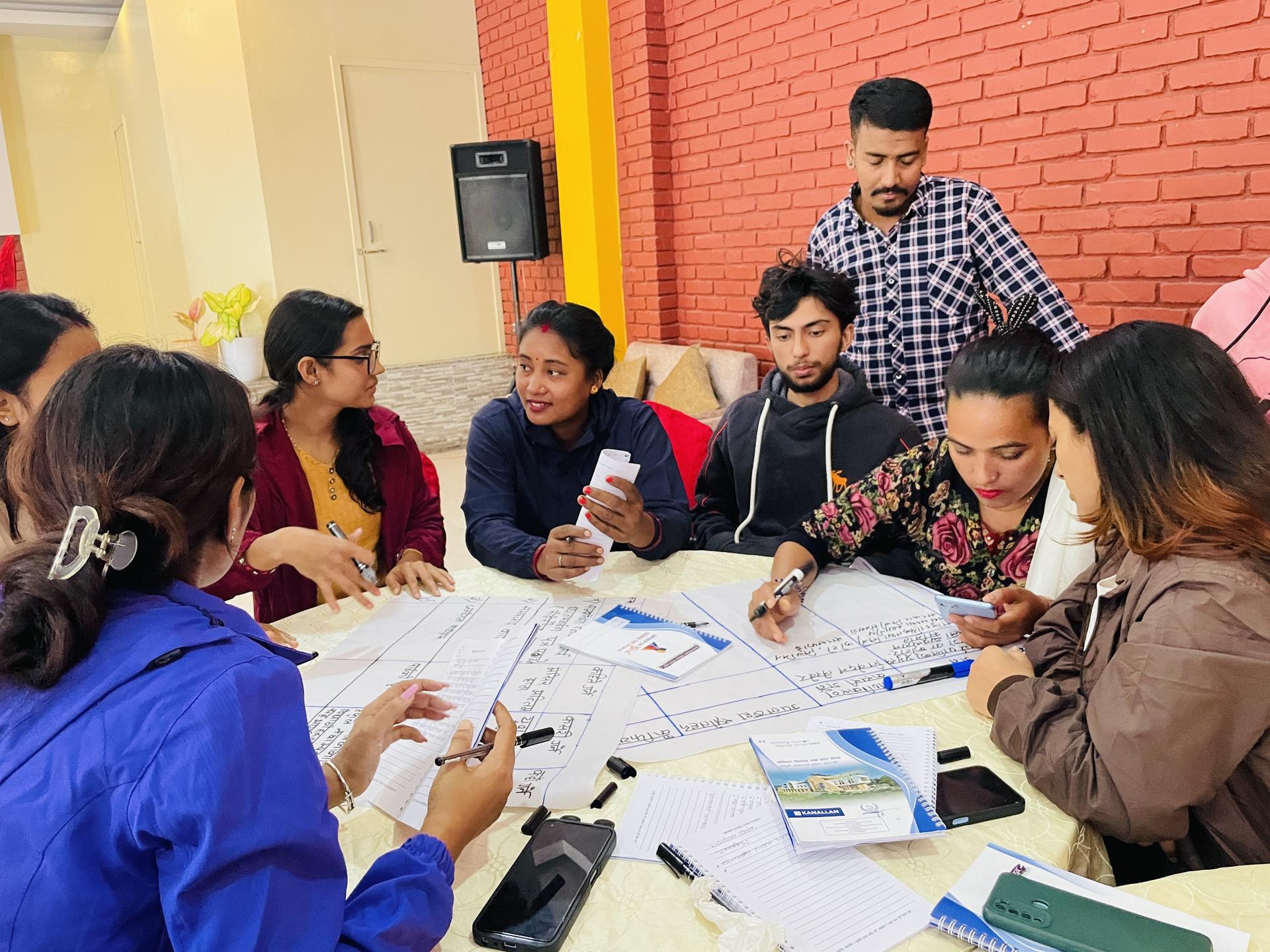 A group of youth engaged in a collaborative discussion around climate change governance.a table with papers.