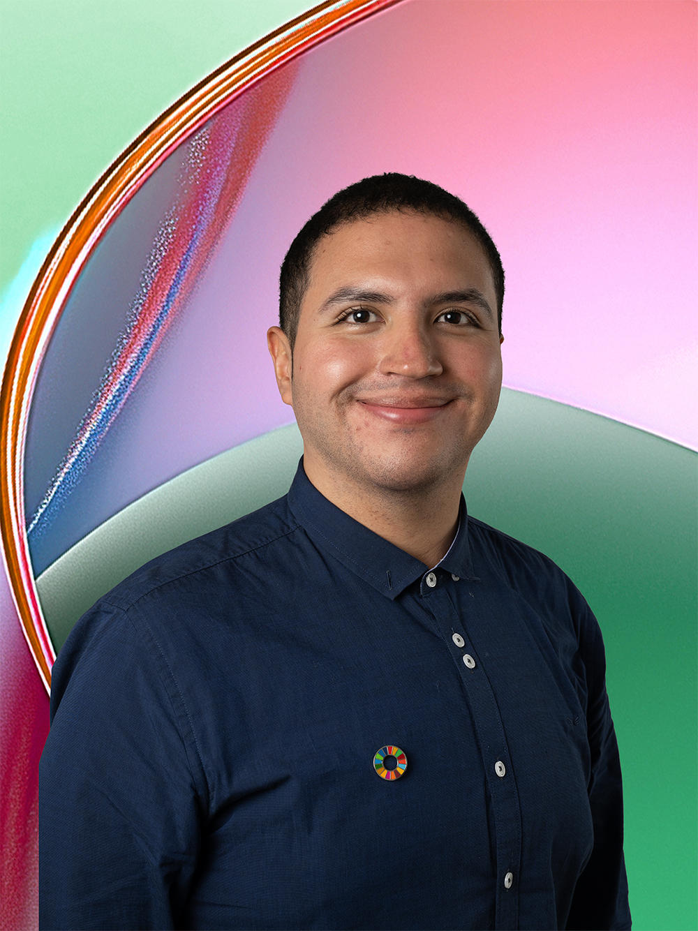 Smiling man in a navy shirt with a colorful background gradient.