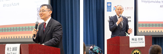 Two speakers at podiums addressing an audience, with blue curtains in the background.
