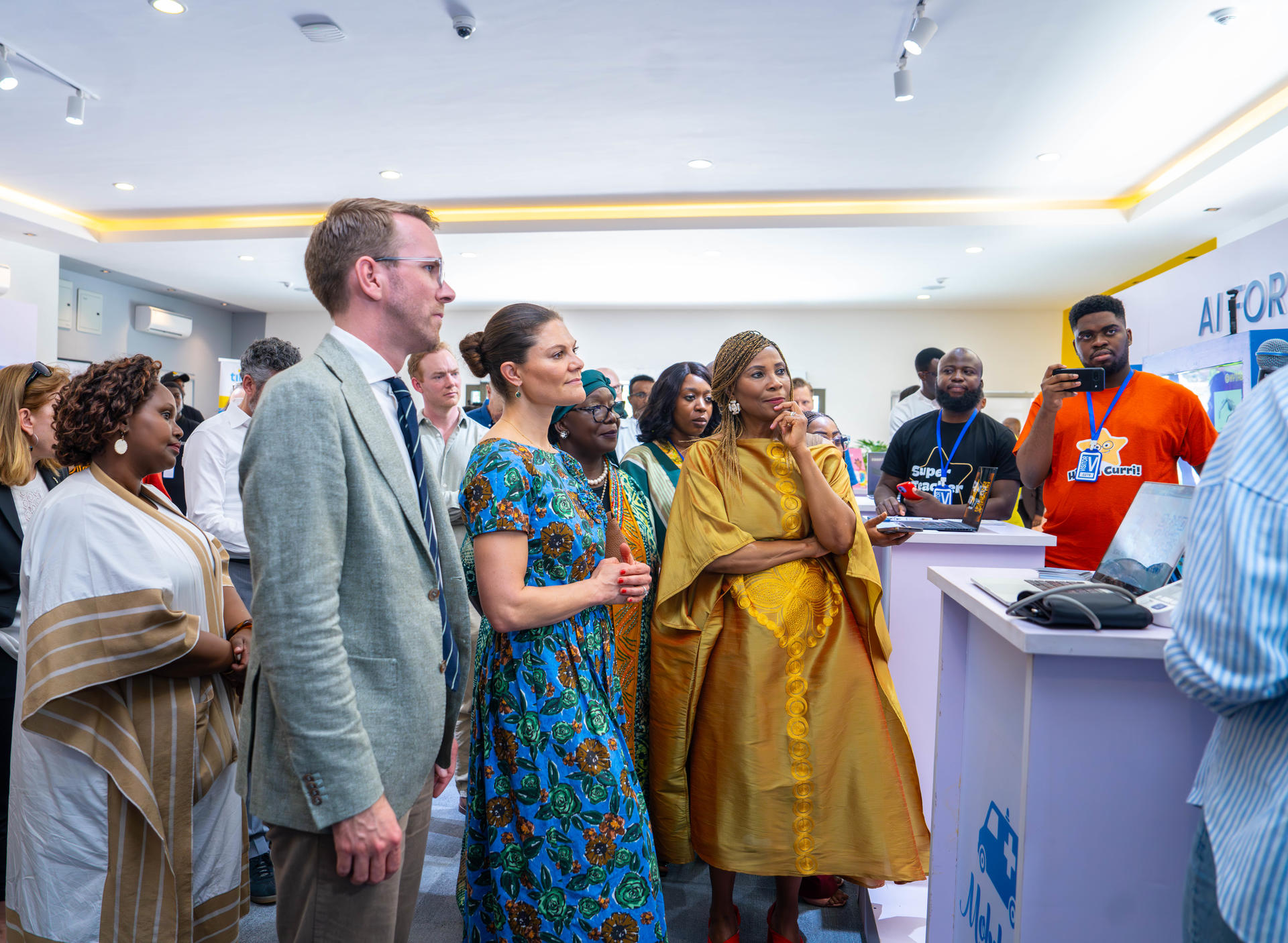A diverse group of people attentively observes a presentation at a professional event.