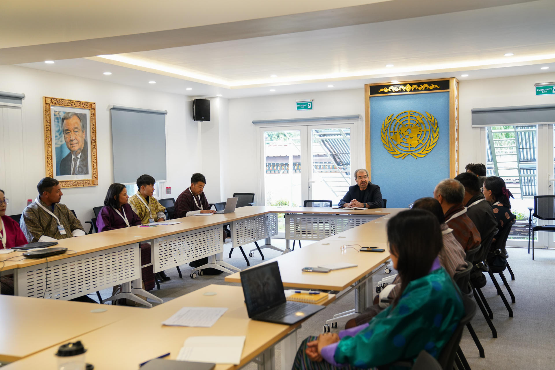 Group meeting in a conference room with participants seated at a long table.