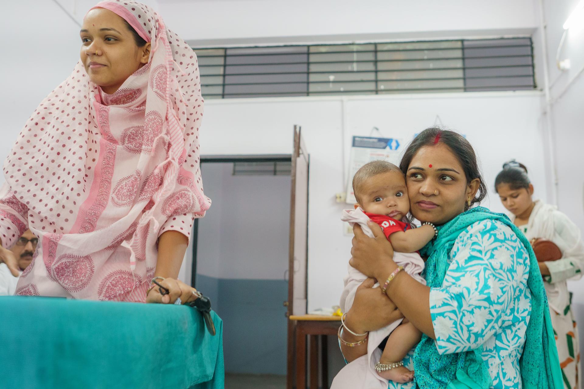 Mother and Child wait at a vaccination centre, India