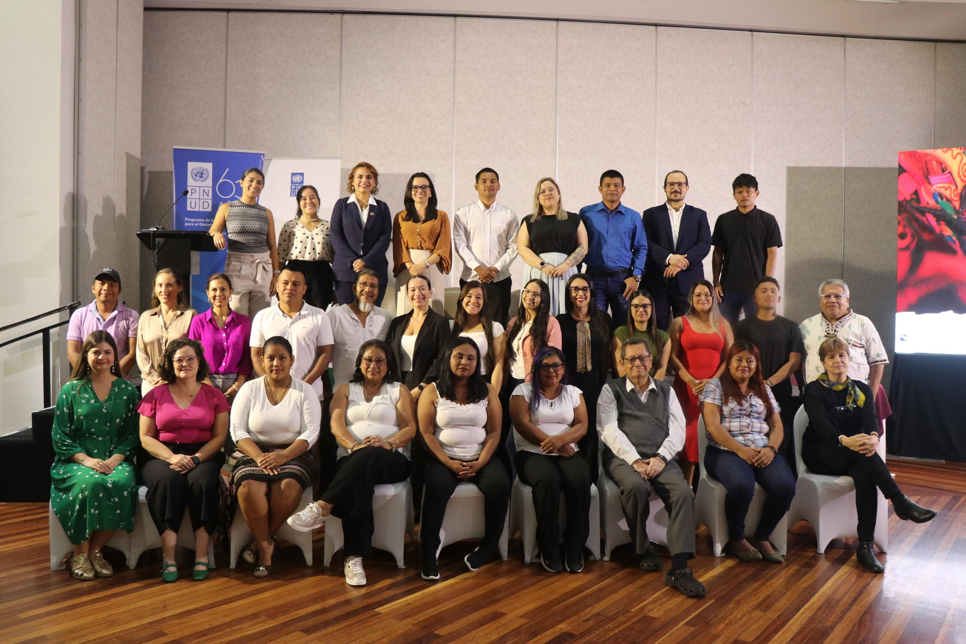 Group photo of diverse individuals posing together in a conference setting.