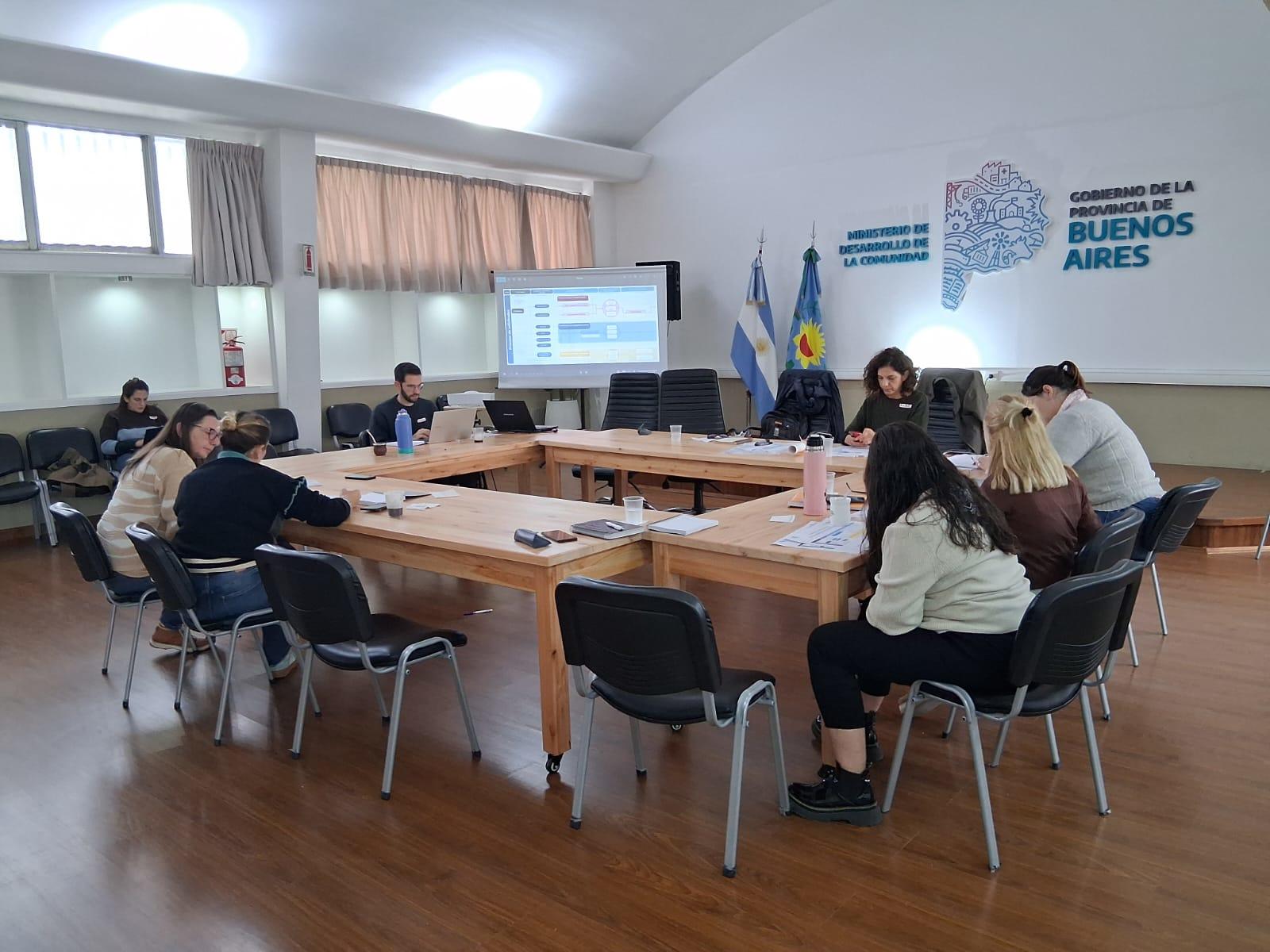 Un grupo de personas sentadas alrededor de una mesa grande en una sala de reuniones.