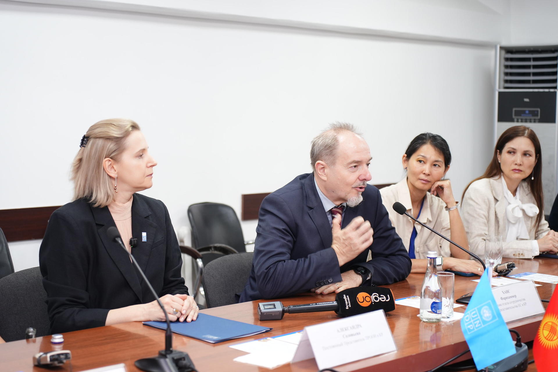 Four people seated at a table during a conference, engaged in discussion.